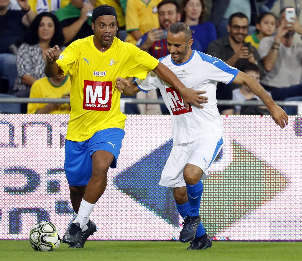 Ronaldinho traslada la pelota ante la sonrisa de su marcador 