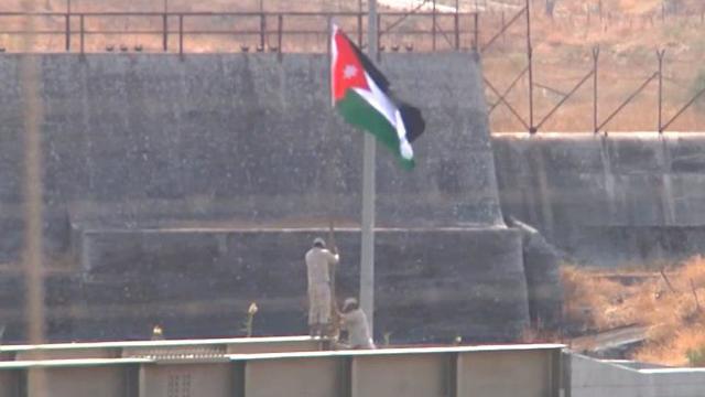 Soldados jordanos izan la bandera jordana en la zona