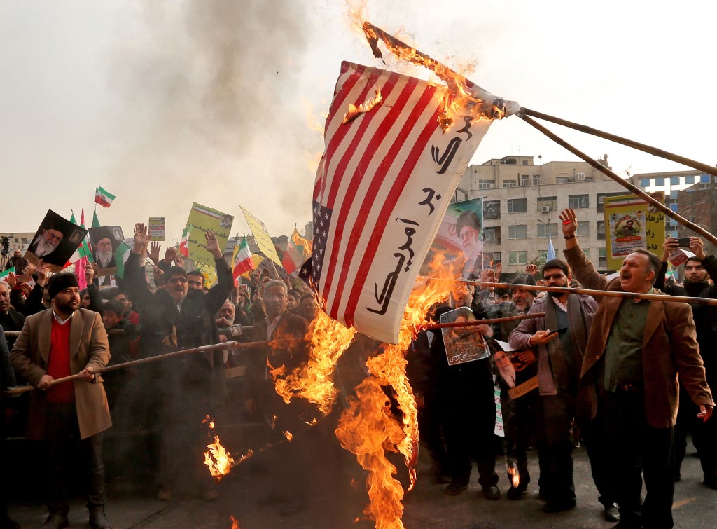 Banderas de Estados Unidos quemadas en la manifestación de apoyo al régimen iraní. 