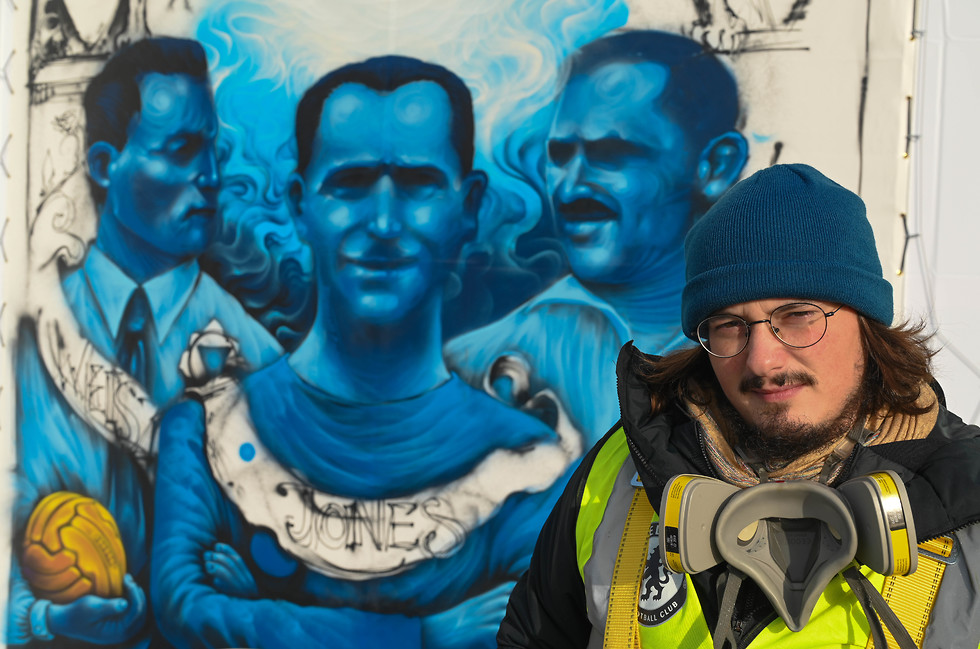 El artista Souza junto al mural que pintó en el estadio del Chelsea 