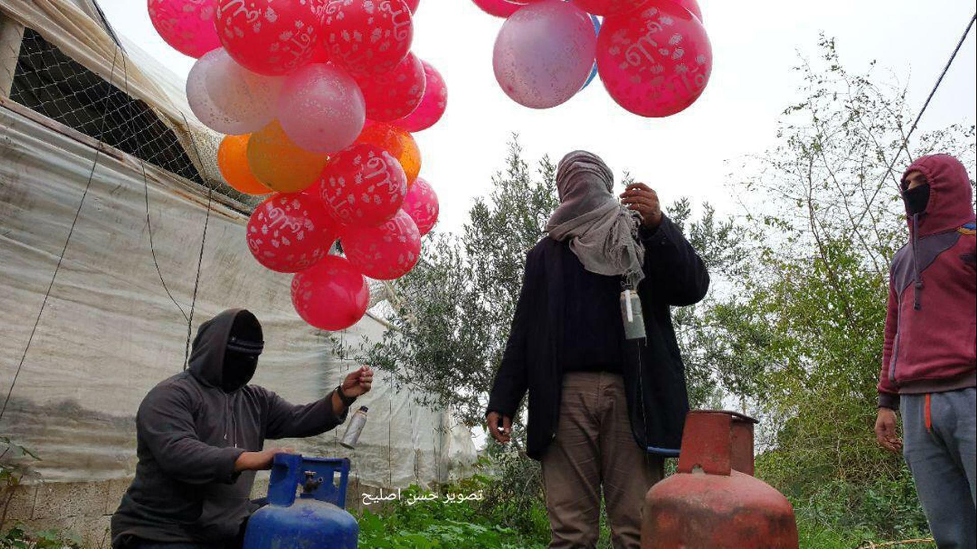 Terroristas palestinos se preparan para lanzar globos incendiarios hacia Israel