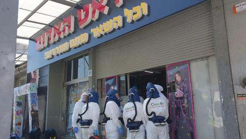 Equipos de cuarentena fuera de la tienda Red Pirate, en el centro de Israel 