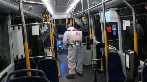 Un trabajador de la salud procede a la desinfección de un autobús