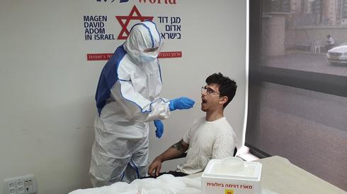 Un funcionario de salud israelí examina a un paciente para detectar coronavirus