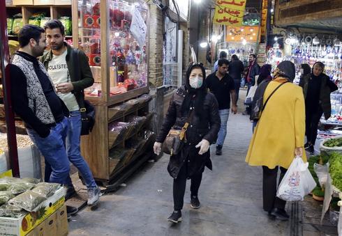 Gente con barbijos en un mercado de Teherán 