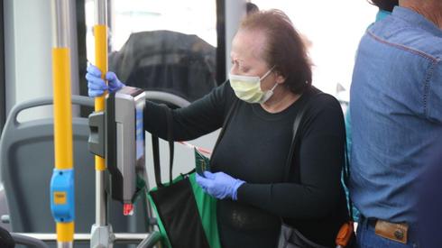 Anciana con máscara quirúrgica en un bus de Tel Aviv