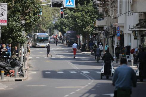 Una calle en un área comercial de Tel Aviv está casi vacía ya que las tiendas y los negocios están cerrados. 