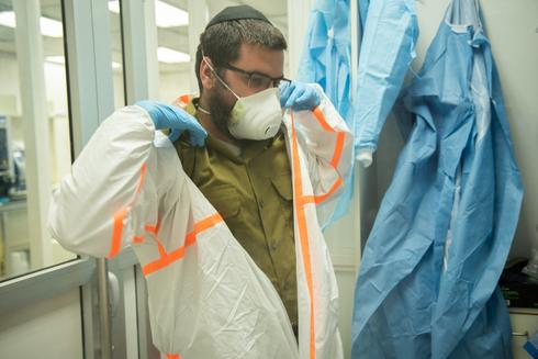 Un soldado de las FDI se pone un equipo de protección en un laboratorio militar que investiga el tratamiento del coronavirus. 
