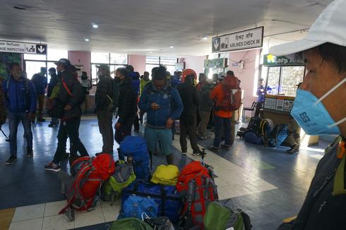 En al Aeropuerto de Nepal, guiía y turistas esperan para registrarse en un vuelo en medio del bloqueo. 