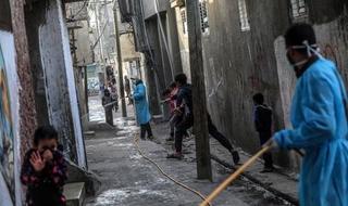 Palestinos desinfectan calles de Al Nusairat, campo de refugiados en el centro de la Franja de Gaza