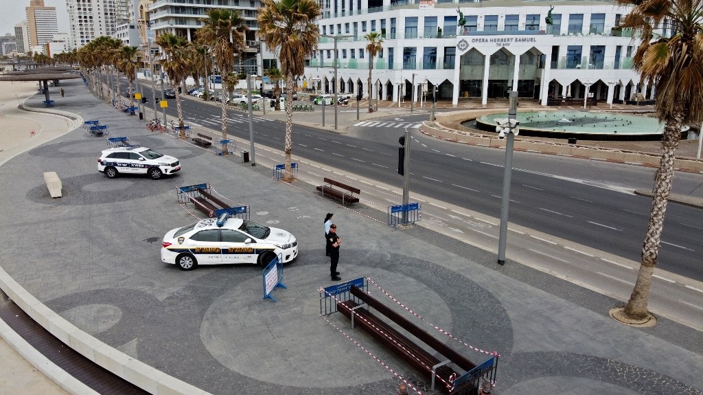 Móviles policiales vigilan la playa de Tel Aviv. 