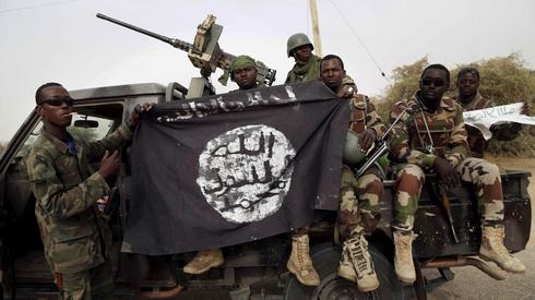 Soldados nigerianos sosteniendo una bandera de Boko Haram. 