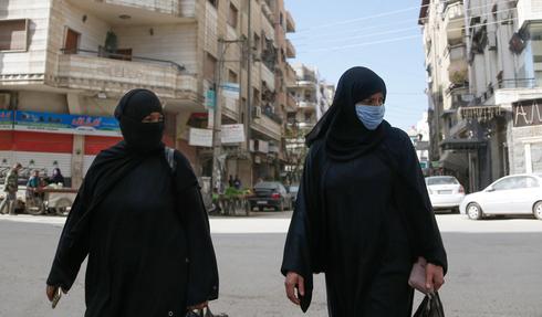 Mujeres sirias, una de ellas con barbijo protector. 