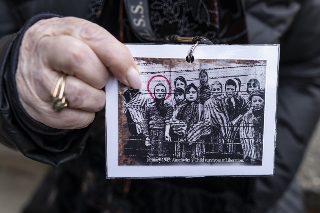 Sobreviviente del Holocausto muestra su foto en Auschwitz al regresar a Polonia. 