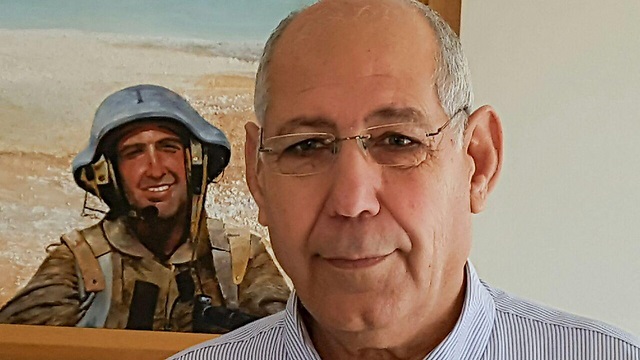 Yaakov Avitan junto al cuadro de su hijo Adi, secuestrado y asesinado por Hezbollah en territorio israelí. 