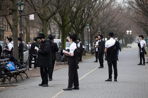 Hombres judíos ultraortodoxos rezando mientras se mantienen alejados unos de otros en Brooklyn, Nueva York durante la pandemia de coronavirus, 