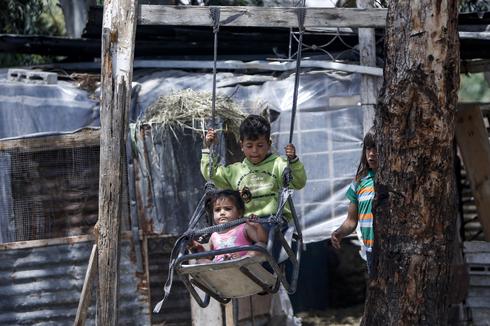 Niños palestinos viajan en un columpio cerca de su casa, al este de la ciudad de Gaza. 