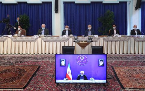 El gabinete iraní, con sus ministros provistos con máscaras protectores, mantiene una reunión virtual con el presidente Rouhani. 