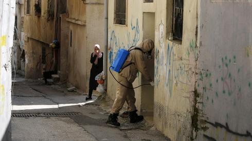 Un trabajador médico palestino desinfectando una casa en Belén 