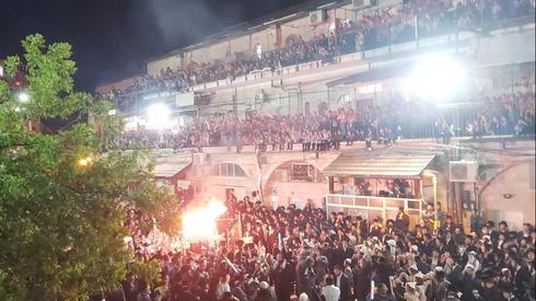 Cientos de personas reunidas alrededor de una fogata en Mea Sharim. 