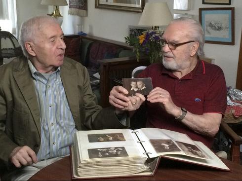 Los hermanos Alexander (izquierda) y Joseph Feingold miran una foto de ellos mismos de niños. 