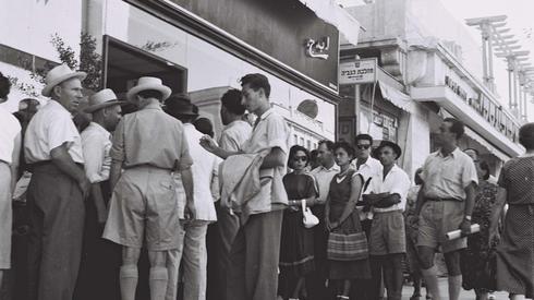 Gente haciendo fila en una tienda durante las medidas de austeridad de la década del 50'. (GPO) Gente haciendo fila en una tienda durante las medidas de austeridad de la década del 50'.
