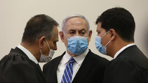 Netanyahu dialoga con sus abogados en el inicio del juicio.