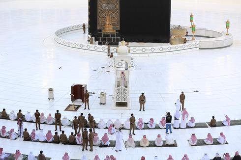 Fuerzas de seguridad se ubican entre los fieles que se rezan frente  la Kaaba en la Gran Mezquita de la ciudad de La Meca, en Arabia Saudita.