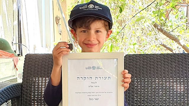 Imri Elia con la placa encontrada y el certificado de reconocimiento entregado por la Autoridad de Antigüedades de Israel. 