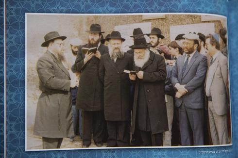 El rabino Levi Banon señala una foto que muestra al rabino Sholom Eidelman, quien murió recientemente después de contraer el coronavirus 