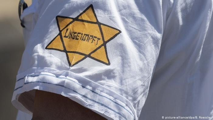 Un manifestante en Alemania con la estrella de David de tela amarilla, en la que aparece la expresión ‘no inmune’ en lugar de la palabra ‘judío’ que figuraba en la de la época nazi. 