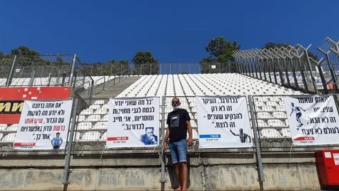 El hincha de Kiryat Shmona y los carteles de apoyo a sus jugadores, con la figura de Maradona entre ellos. 