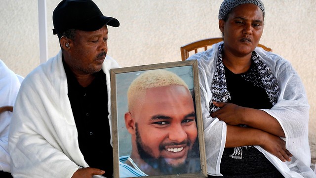 Los padres de Solomon Teka muestran su foto, mientras guardan luto, en julio de 2019.