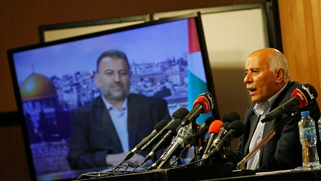 Jibril Rajoub, referente de Fatah, y Saleh al-Arouri (en la pantalla), miembro del liderazgo de Hamás, durante una declaración conjunta contra la anexión.