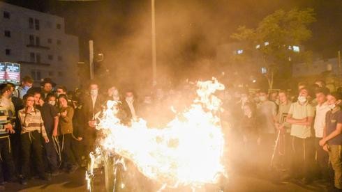 Manifestantes queman un contenedor de basura durante la protesta contra la cuarentena impuesta en algunos barrios de Jerusalem. 