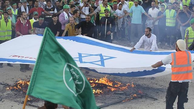 Partidarios de los Hermanos Musulmanes prenden fuego una bandera de Israel en Jordania durante la operación 'Margen Protector' de las FDI en Gaza en 2014. 