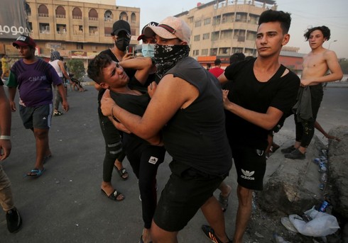 Manifestantes asisten a un manifestante herido en Bagdad.