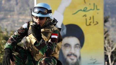 Un miembro de la FPNUL frente a un cartel del líder de Hezbolá Hassan Nasrallah en el sur del Líbano. 