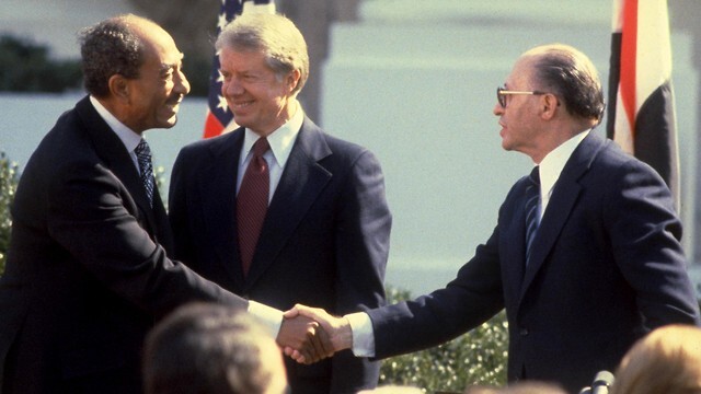 El presidente estadounidense Jimmy Carter felicita a su par egipcio Anwar Sadat y al primer ministro Menachem Begin tras la firma del tratado de paz entre Israel y Egipto. 