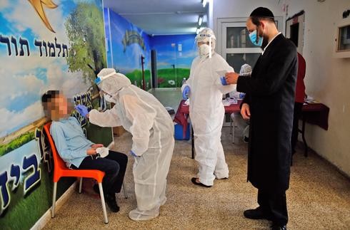 Trabajadores de salud realizan el test de coronavirus a un alumno de una escuela en Rehovot. 