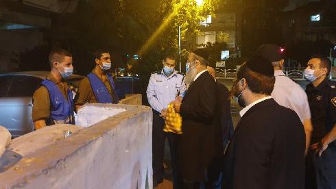 El alcalde de Bnei Brak, Avraham Rubinstein, le habla a los soldados y policías que imponen el toque de queda nocturno de la ciudad. 
