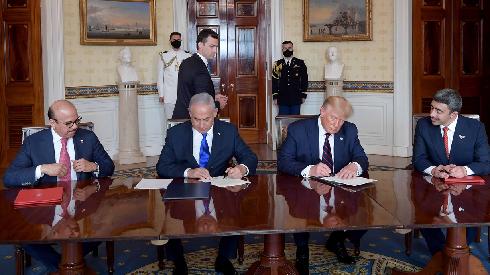 Los líderes firman ayer en la Casa Blanca.