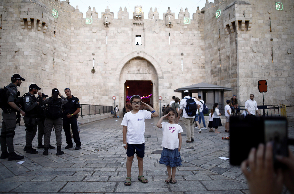Los niños saludan a las fuerzas de seguridad de guardia en la entrada de la Ciudad Vieja de Jerusalem durante Yom Kipur. 