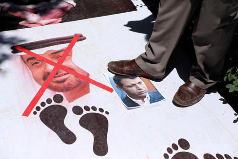 Palestinos pisan las imágenes del Mohammed bin Zayed, príncipe heredero emiratí, y de Mohammed Dahlan, durante una protesta en Naplusa.