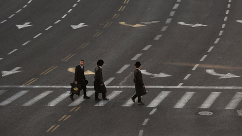 Tres personas caminan por las desiertas calles de Jerusalem.