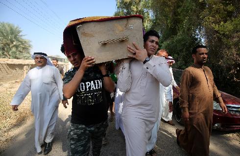 Iraquíes trasladan un cajón con los restos de una de las víctimas del ataque del lunes. 
