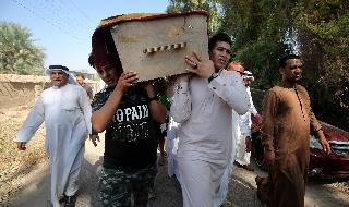 Iraquíes trasladan un cajón con los restos de una de las víctimas del ataque del lunes. 