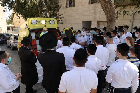 Estudiantes de Yeshivá reunidos alrededor de una unidad móvil de pruebas de coronavirus de Magem David Adom en Jerusalem. 