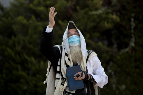  Un haredí reza al aire libre y con una máscara durante el encierro en Jerusalén. 