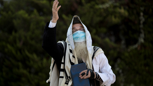  Un haredí reza al aire libre y con una máscara durante el encierro en Jerusalén. 